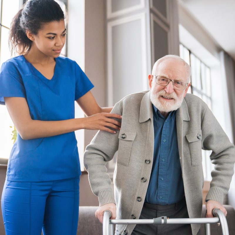 handicapped-man-using-walker-rehabilitation-at-home-nurse-helping-disabled-man-using-walker.jpg